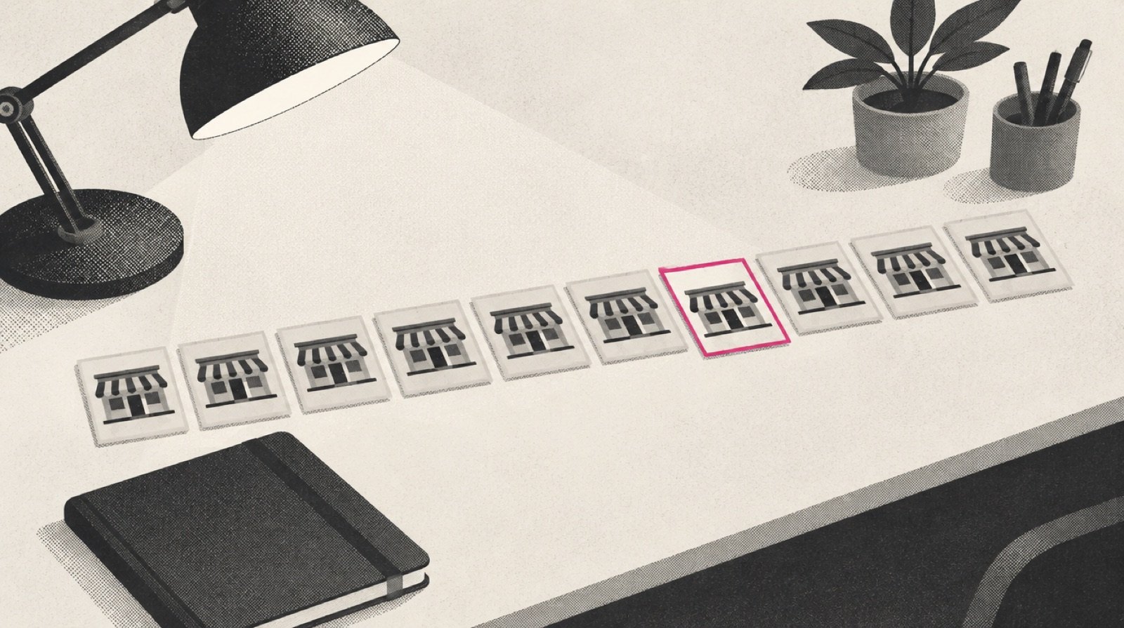 A franchise development desk with a row of small identical location cards laid out in a line, one card slightly out of line and edged in magenta, beside a reading lamp and a closed notebook